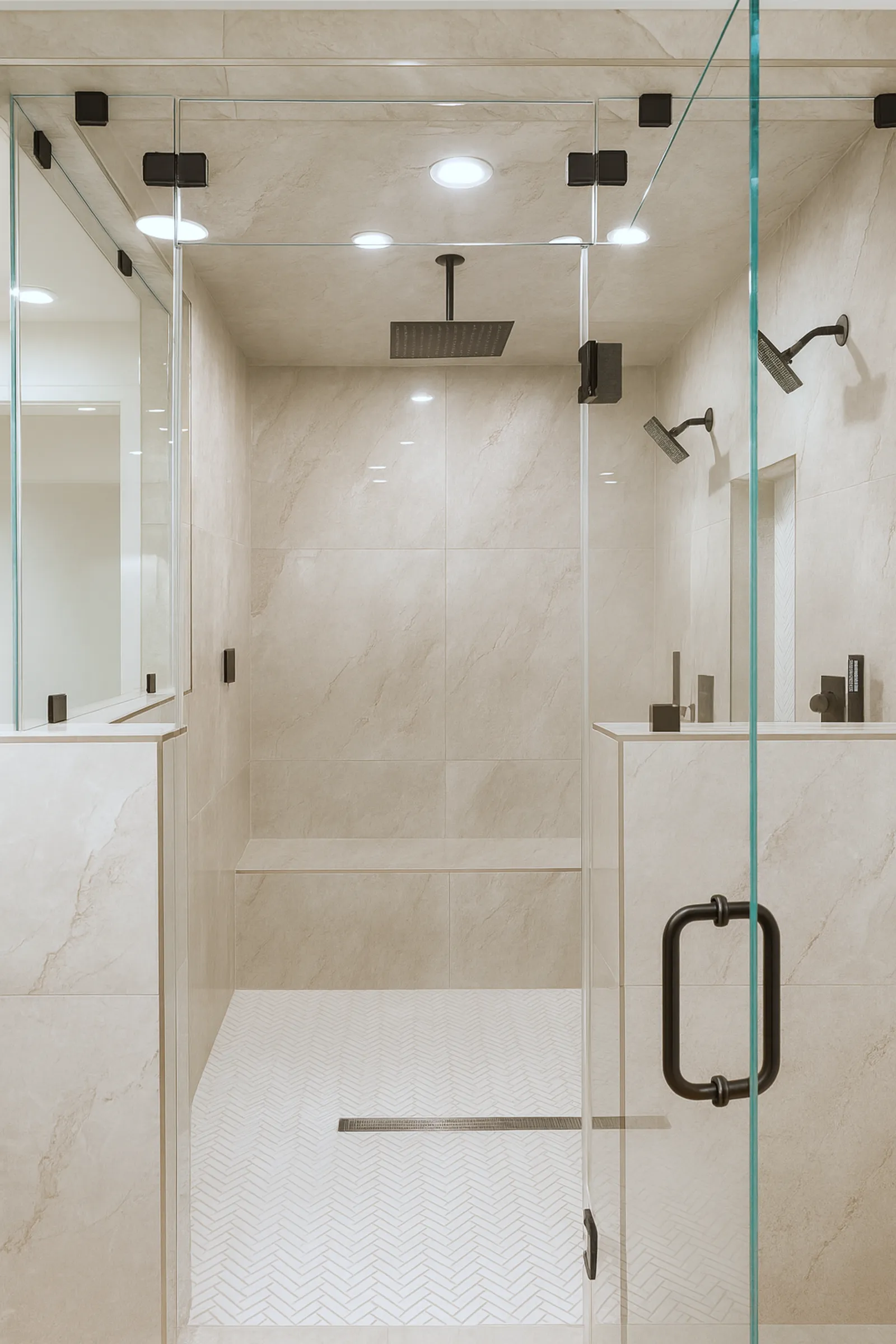 Floating wood double vanity with a white trough sink, two black faucets, and a backlit mirror