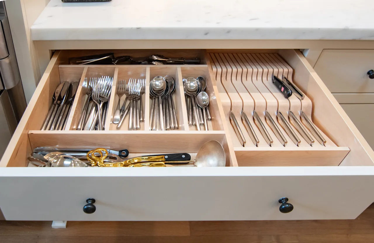 Kitchen drawer with custom maple compartments organizing cutlery and knives
